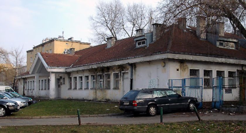 Stare zdjęcie budynku na Mokotowie. Zniszczony dach, ściany. W tle samochody, jezdnia, brama. 