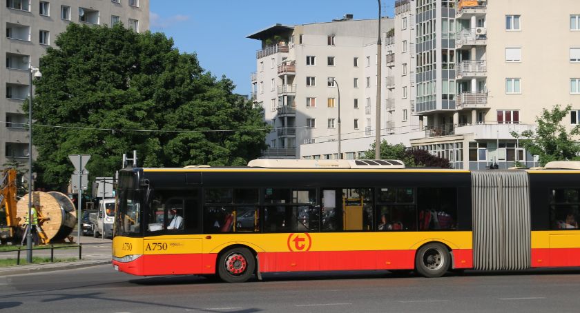 Autobus, w tle budynki mieszkalne.