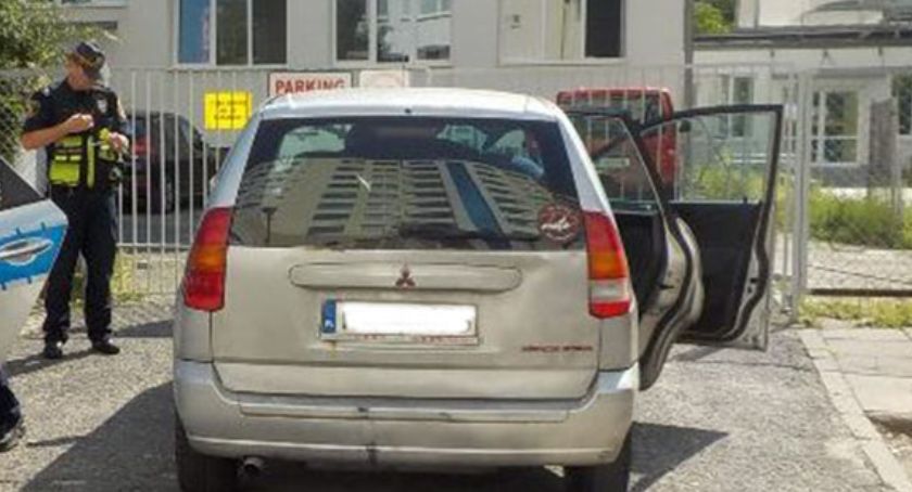 Samochód przed bramą, strażnik miejski.